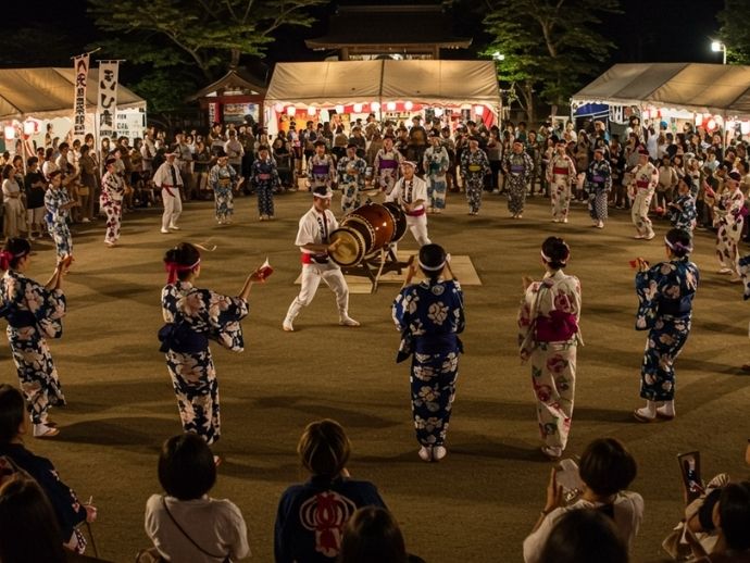 お台場夏祭りで櫓を囲んで踊る浴衣姿の参加者たちと夜の提灯の光景
